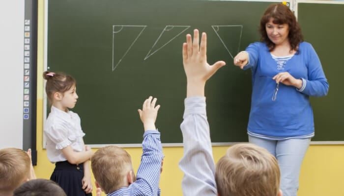 A female teacher teaching students in a classroom